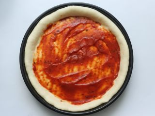 15、鸡肉蔬菜披萨,在发好的披萨皮上面涂上一层披萨酱