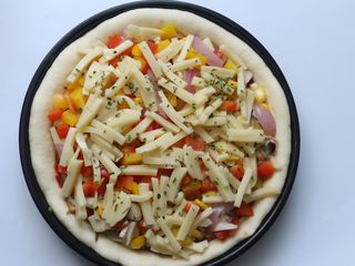 18、鸡肉蔬菜披萨,然后再撒上最后的100克芝士条，再放入适量的欧芹片即可