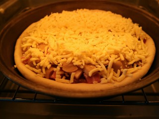 10、培根口蘑芝香披萨,预热烤箱后,把披萨饼放入烤箱中层,上下火150℃,烤大约25分钟。