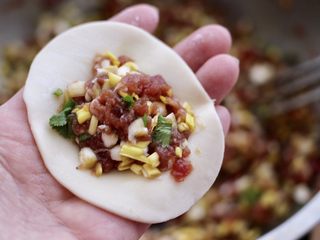 12、蒜黄牛肉饺子,取一个饺子皮，放入调制好的馅料。