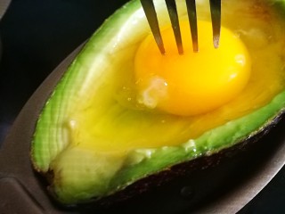 18、百变鸡蛋～牛油果焗蛋,用叉子扎破蛋黄