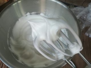 5、八寸加高中空戚风,蛋白放入盆，盆子需无油无水。糖分三次加入蛋白内打发。出现鱼眼泡加入第1次糖，蛋白细腻加入第2次糖，出现纹路加入第3次糖，继续打发至拉起打蛋器呈直立的尖角。