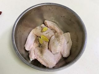 4、韩式吮指炸鸡翅,往鸡翅内加入盐、黑胡椒和姜片。