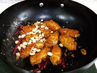 13、韩式吮指炸鸡翅,让鸡翅裹上慢慢的酱汁，最后撒入花生翻动下即可出锅。