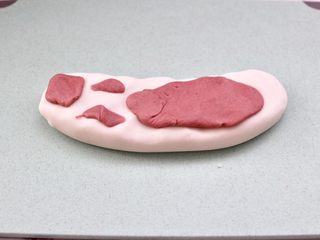 11、年年有余之-锦鲤年糕鱼,先取一块白色的小面团,搓成鱼的大概形状,然后再取一点红色的面团,随意搭配在白色面团上面。