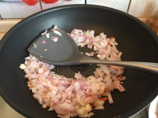 6、东南亚下饭神菜SISI,起油锅放入洋葱和红椒粒煸炒出香味