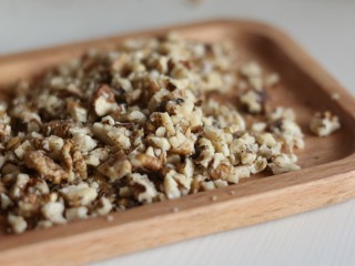 2、中式点心:传统桃酥,将剥好的核桃仁装入保鲜袋，用擀面杖压碎。