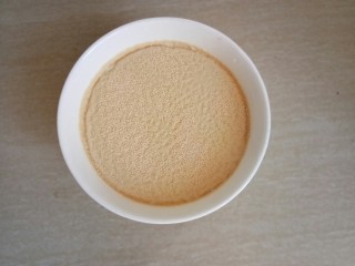 2、萌萌的小猪包,取190克温水撒上酵母静置5钟。