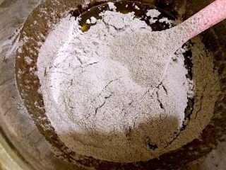 4、好吃到爆的可可蔓越莓椰蓉月饼,把混合好的粉过筛到油糖浆里