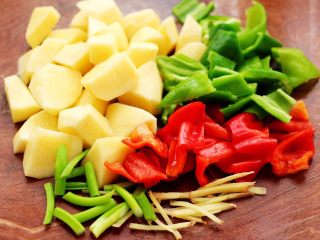 3、鸭腿烧双椒土豆,土豆去皮后洗净,用刀切成菱形块,青红椒切成薄片,葱姜切丝。