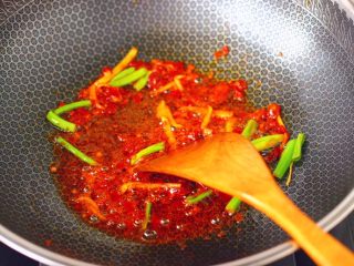 6、鸭腿烧双椒土豆,另起锅烧热后,倒入花生油烧至六成热时,爆香葱姜丝,再倒入郫县豆瓣酱翻炒出红油。