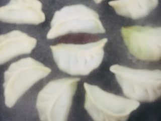5、包蛋煎饺,加入适量清水没过饺子的一半处