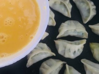 11、包蛋煎饺,待锅中水分收干时，延锅边慢慢倒入蛋液