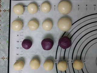 9、双色蛋黄酥,取出静置好的油皮：秤重分成10分等份、再将其中4等分合并成2等份，既2大6小合计8份； 取出油酥：将白色和紫色油酥，分别秤重分成5小份，再将其中4份紫色油酥合并成2等份、既2大1合计3份，如图搓圆备用