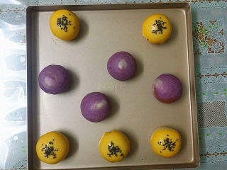 22、双色蛋黄酥,全部包好放入烤盘，在原味蛋黄酥面坯上刷层蛋黄液、再撒少许黑芝麻点缀