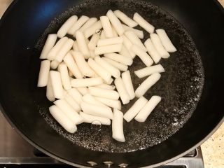 2、韩国辣酱炒年糕,锅内倒入适量清水煮沸，年糕入锅煮软