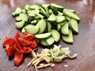 2、海鲶鱼焖萝卜,萝卜洗净后，用刀切两瓣后切薄片，红椒切成大片，葱姜切碎。