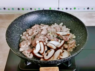 10、香菇肉片,再加入切好的香菇片翻炒。