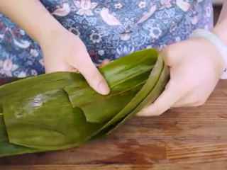 8、鲜肉粽子,取洗净粽叶两片，齐反时针方向旋转形成密封的漏斗状