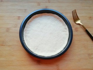 5、百变水果 水果披萨,放进披萨盘里，用手把大出来的部分压实，使其贴在披萨盘的边上。