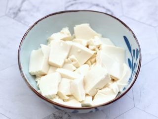 6、飞蛤豆腐鸡蛋羹,把内脂豆腐切成薄片放入碗中。