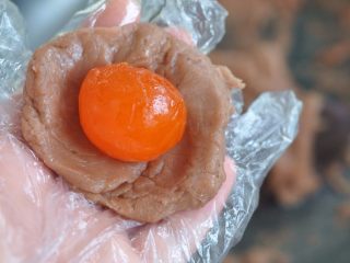 9、香芋蛋黄酥,把香芋馅取25克，压扁后放入咸蛋黄，包起来。真空包装的咸蛋黄，使用前需要在油里浸泡三天。