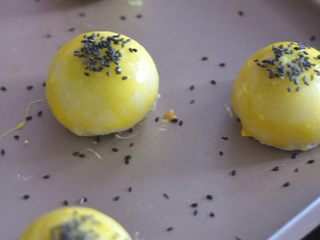 13、香芋蛋黄酥,10分钟后取出，表面再刷一层蛋黄，表面撒上黑芝麻，放回烤箱，170度继续烘烤25分钟。