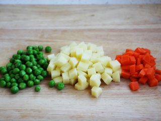 5、咖喱土豆胡萝卜鸡丁饭,将豌豆清洗干净，土豆切丁，胡萝卜切丁。