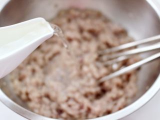 7、烟台正宗鲅鱼饺子,分次加入适量清水来搅打鱼馅、因为鲅鱼的新鲜度不一样、我加了200克清水。