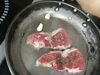 10、迷迭香黑胡椒牛排,放入几头蒜粒，给油加点蒜香味，有带皮蒜更好了，最后可以吃点