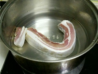 3、香煎腊肉,煮锅里倒入适量清水,放入腊肉煮熟;