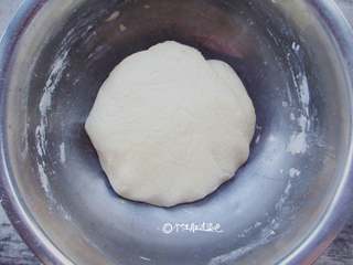 2、奶香玉米耙,一边加牛奶,一边搅拌。用手揉面揉至光滑即可。