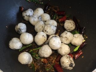 8、贵州+酸菜炒汤圆,再倒入炸好的汤圆，翻炒，均匀撒上适量盐调味，翻炒均匀