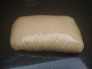 6、广式月饼~网红大螃蟹咸蛋黄月饼,用保鲜膜把月饼皮面团包好室温静置松弛2个小时，如果室温过高可放冰箱冷藏3个小时：