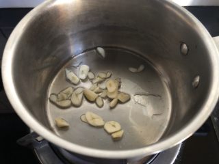 5、小奶锅煮日式南瓜,加入蒜片,转小火略煎。