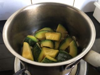 8、小奶锅煮日式南瓜,颠一下锅,再干煎一分钟。开盖,南瓜块边缘略焦即可进行后续步骤。