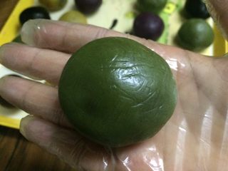 10、五彩桃山皮月饼,开始包馅了,带上手套操作,皮压成圆饼形。
