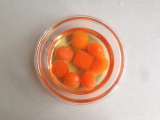 2、蛋黄豆沙月饼,倒入玉米油，玉米油刚好没过咸蛋黄，放冰箱冷藏放置2、3天再使用