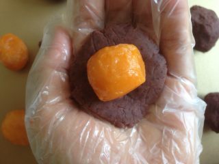 4、蛋黄豆沙月饼,豆沙馅压扁一下，放入整个蛋黄