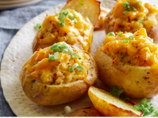 4、奶酪烤土豆,用盐和胡椒粉撒在土豆皮。将土豆泥混合物填充至土豆壳。放入烤箱再烤2-3分钟立即上桌。