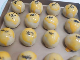 14、中秋月饼怎么做？手把手教你做蛋黄酥 ,全部包好后要刷纯蛋黄液撒黑芝麻  ，这样颜色比较黄也比较好看