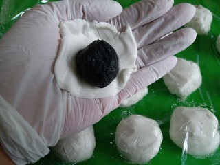 7、黑芝麻汤圆,拿一个面团在手心按扁，放上芝麻馅儿，包好捏紧收口！再搓圆，依次做好。吃不完的汤圆放冷冻室冻起来，想吃的时候便拿出来煮，无需解冻！