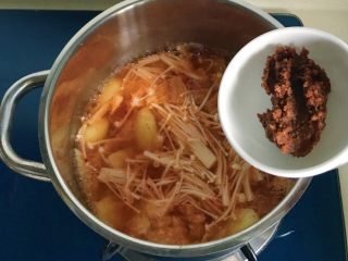 12、酸辣泡菜锅,加入大酱，用筷子或者勺子把成块的大酱搅拌开，也可以加少许水先把大酱融化后再倒入锅中