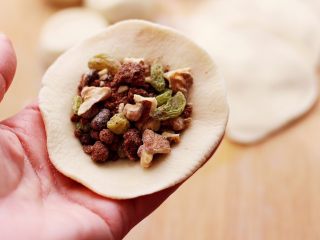 12、果仁红糖发面饼,擀好的面皮里,放入适量的馅料。