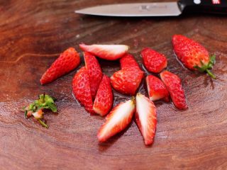 3、草莓酒酿百合鸡蛋羹,草莓洗净后，去掉草莓蒂，用刀切成块。