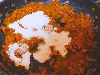 6、南瓜火腿意面,加入淡奶油炒匀，如果太稠了可以加些牛奶或者水，然后撒点盐