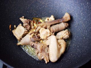 7、土鸡土豆粉条一锅炖,这个时候放入焯过水的土鸡块,大火翻炒均匀。