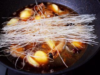 13、土鸡土豆粉条一锅炖,放入洗净的粉条,盖上锅盖大火烧开后,继续炖煮10分钟左右。