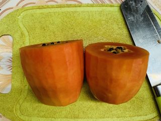 2、木瓜奶冻,去皮去头尾，注意不要切太多漏馅了，然后横着中间切开。