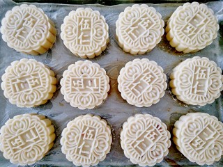 11、广式月饼,五仁馅的比较简单一些,直接把皮擀薄,把馅料放在饼皮上面,把饼皮慢慢往上推,收口,搓圆,收口朝下,模具里面撒一些干粉,把模具转一圈,再把多余的粉倒掉,再把包好的月饼放进模具里,直接压在放了油纸的烤盘里,压模的时候要用点力度,压好后手松开,待模具手杆回升后,再用两手抓住手杆把月饼慢慢往下推,一个月饼就出来了。